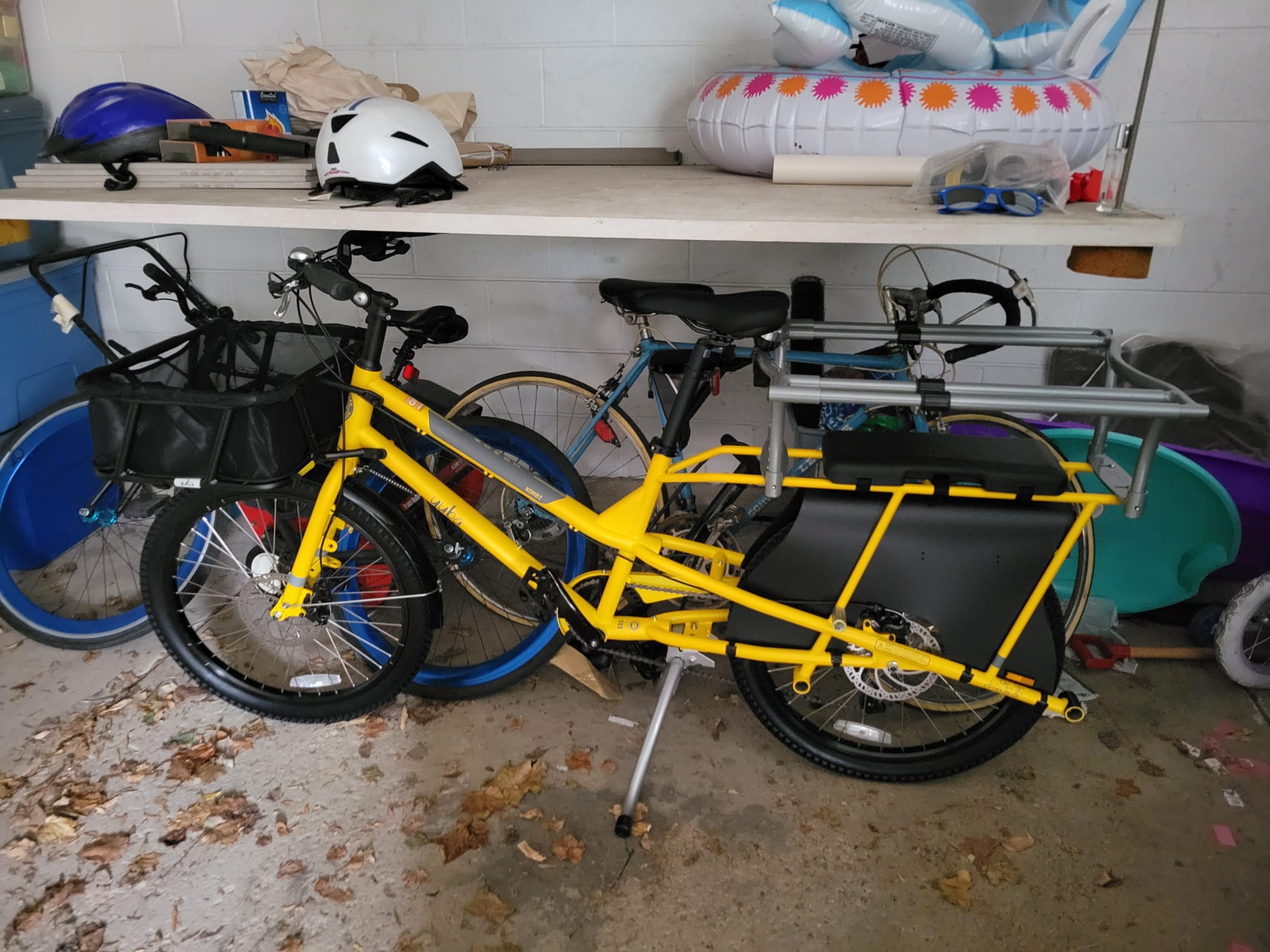 Yuba Kombi cargo bike with basked and monkey bar bench seat. Yellow