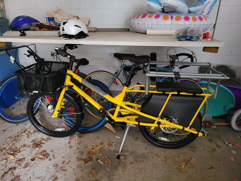 Yuba Kombi cargo bike with basked and monkey bar bench seat. Yellow